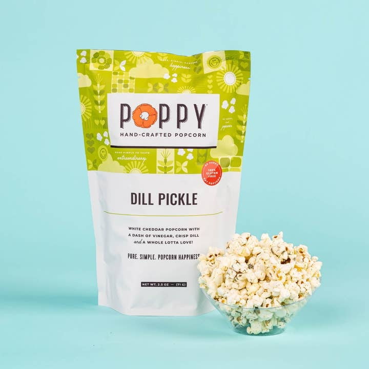 Open bag of white cheddar dill popcorn with visible green herbs.