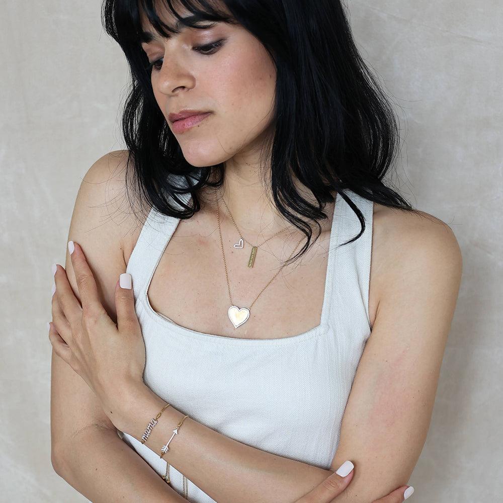 Sterling silver pendant necklace with gold-plated finish featuring a heart-shaped silhouette set with small diamonds.
