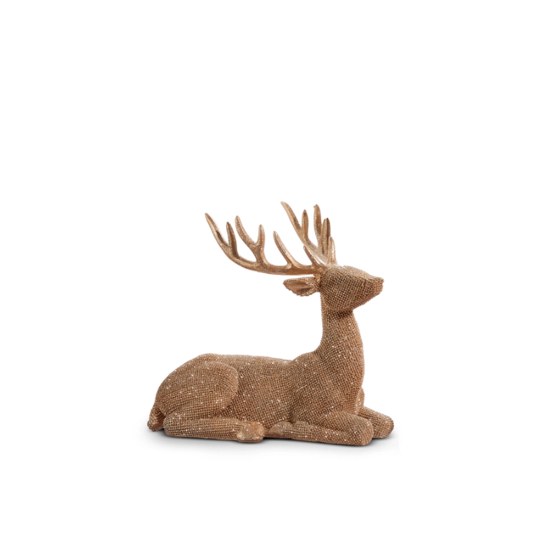 A decorative bronze glittered deer figurine in a sitting position with large antlers.