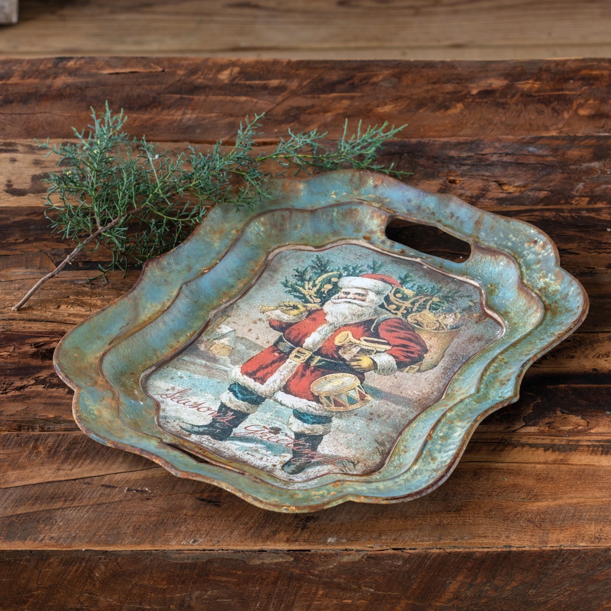 Vintage-style Santa Bearing Gifts decorative tray with scalloped edges on a rustic wooden surface.