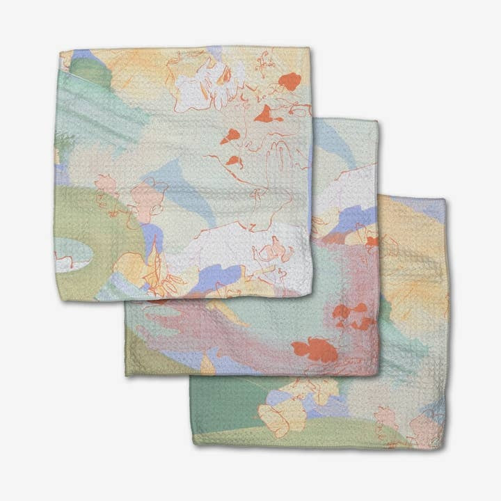 Set of three waffle weave dishcloths in neutral tones with single-sided prints and hanging loops.