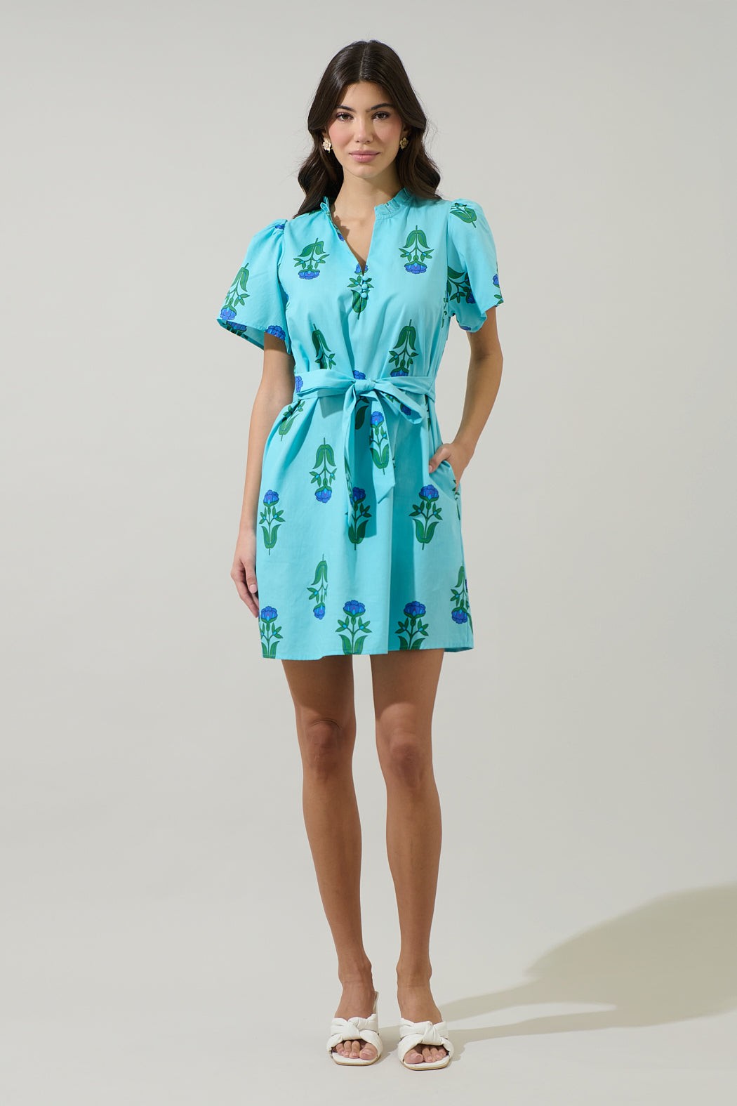 Amena Floral Ema Shift Mini Dress in light blue with a split neck, tie belt, and short puff sleeves.