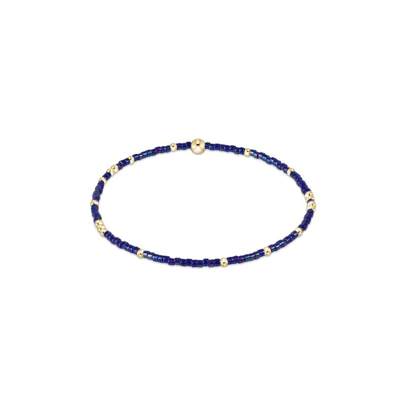 Hope Unwritten bracelet featuring mixed seed beads in various colors with gold accents on elastic cord.