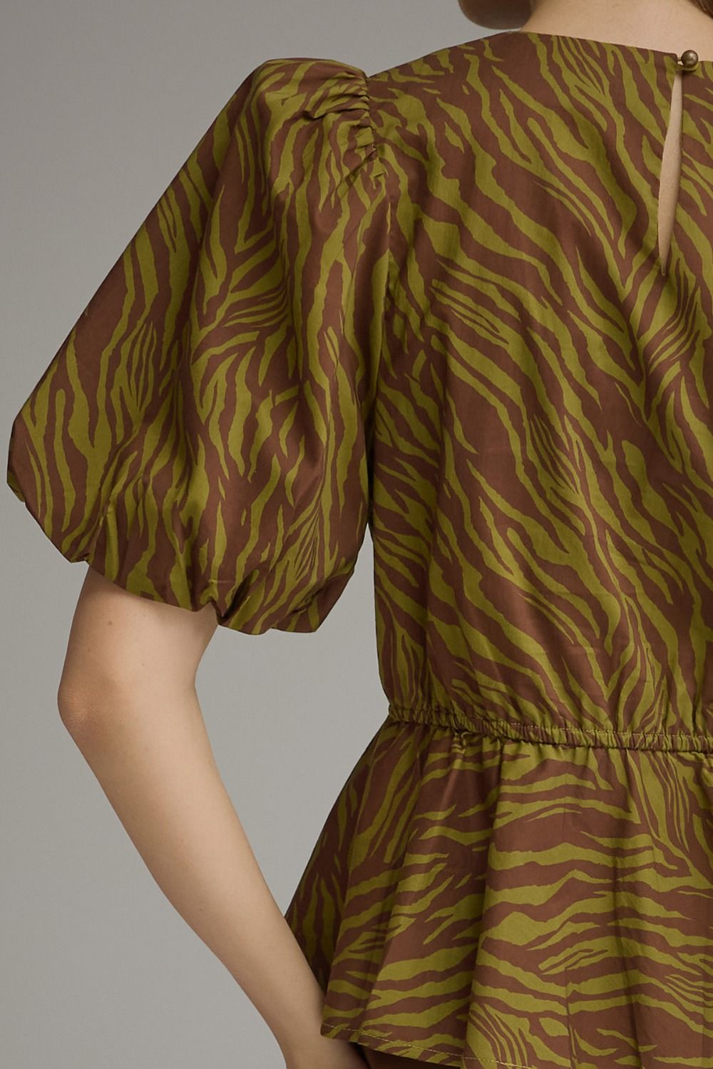 Back view of a brown and olive green zebra print top with short puff sleeves and elastic waist.
