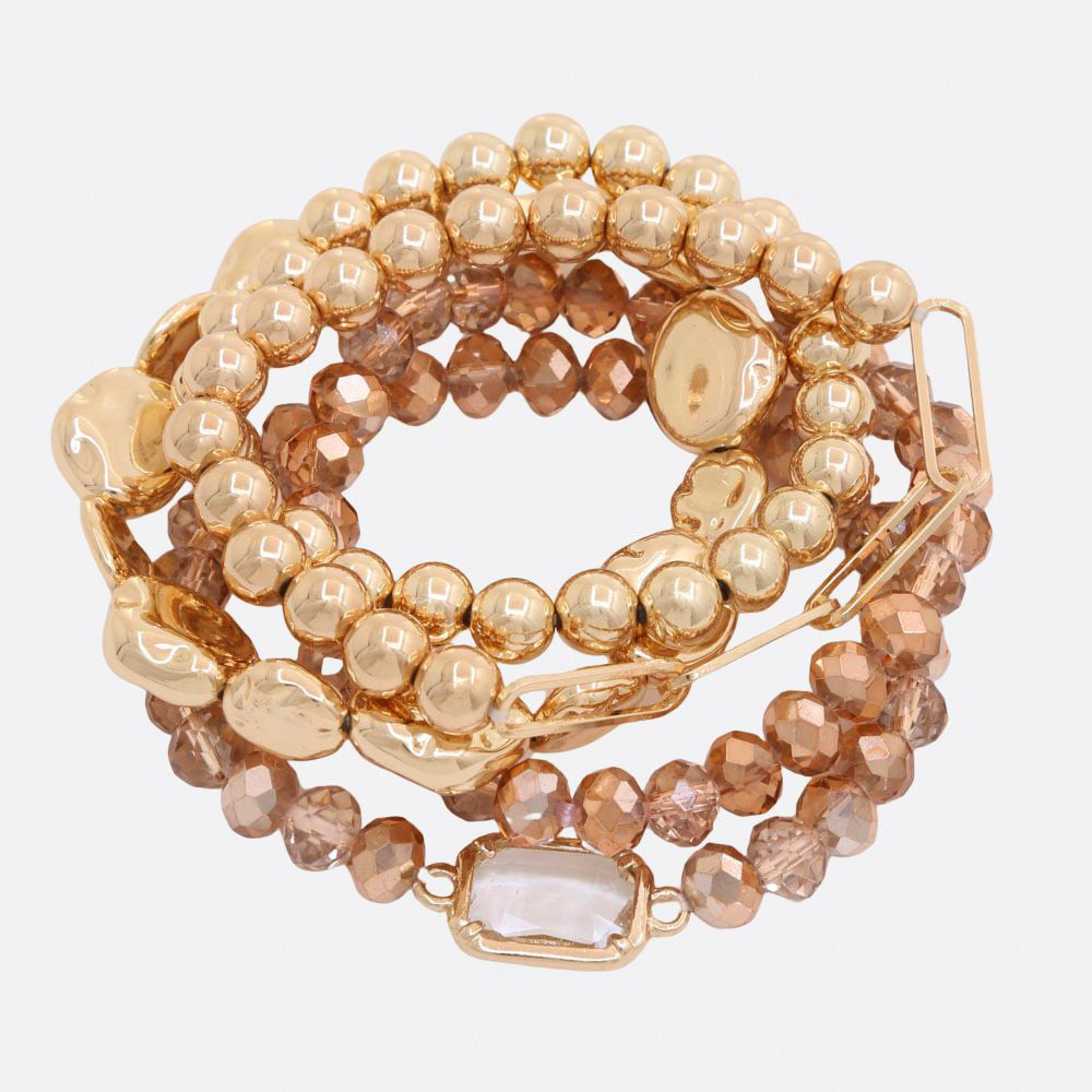 Gold beaded bracelet set with faceted beads, smooth gold spheres, and a clear rectangle charm.