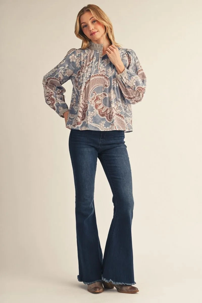 Woman wearing the Adeline long sleeve boho paisley floral top in blue and brown with flare jeans.
