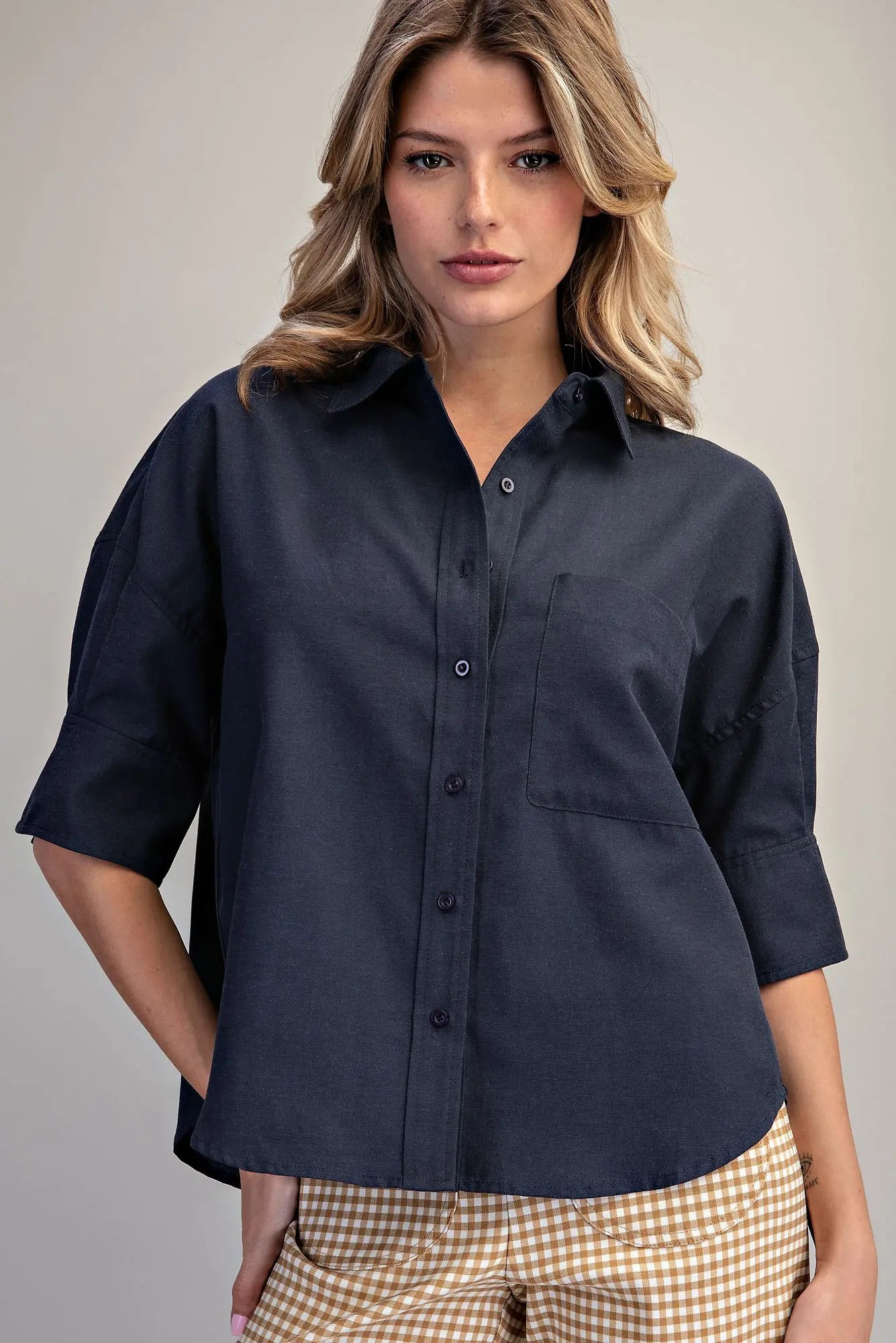 Woman wearing a navy blue Lou Button Down Short Sleeve Shirt with a chest pocket and relaxed fit.