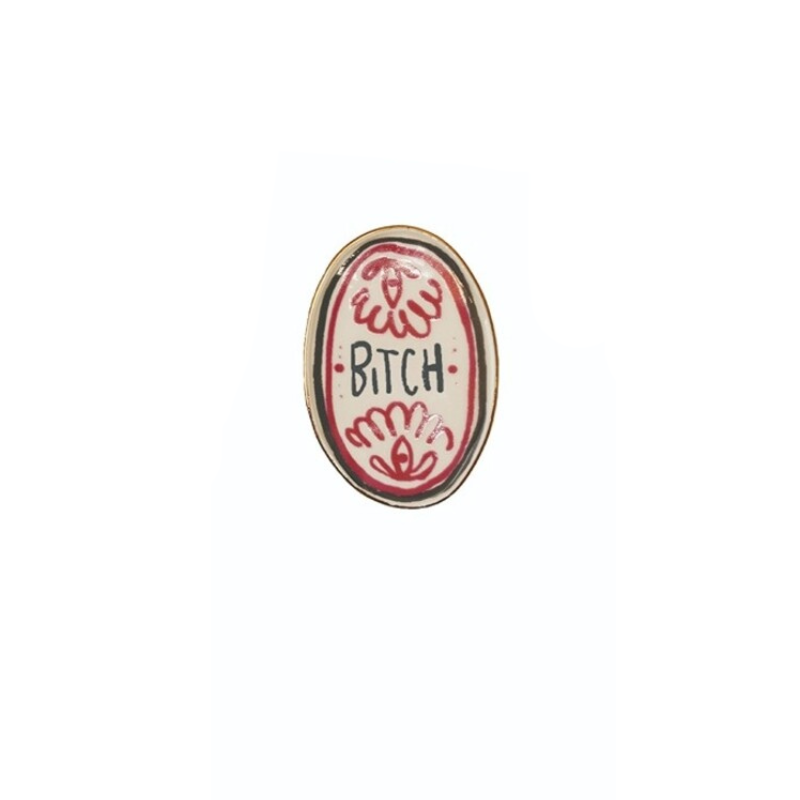 Oval stoneware magnet with red floral patterns and the word "BITCH" in black text.