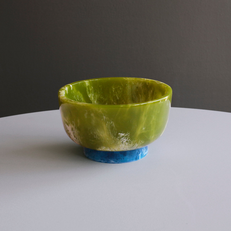 Green marbled resin Rio small bowl with a contrasting blue base on a white surface.