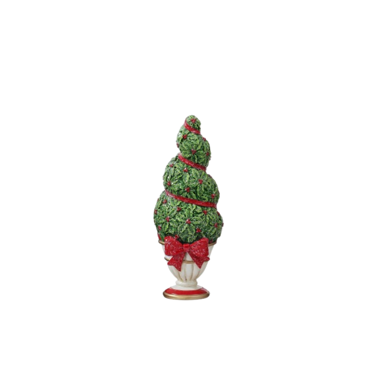Resin potted holiday topiary with green holly leaves, red berries, and a red bow in a white urn.