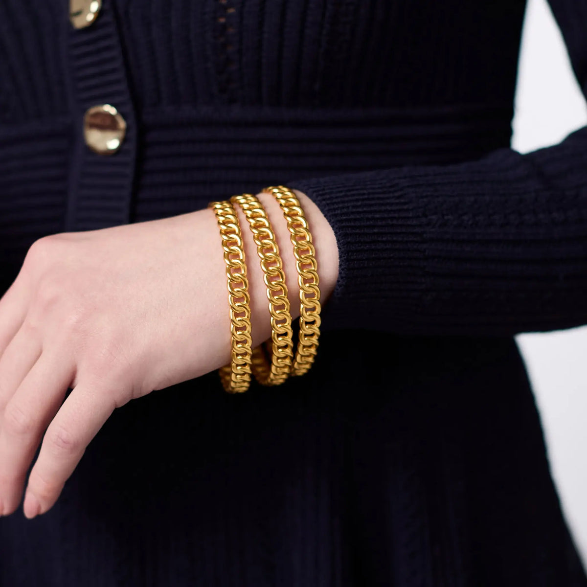 Dolce Bangle in polished gold-tone metal with a smooth round silhouette.