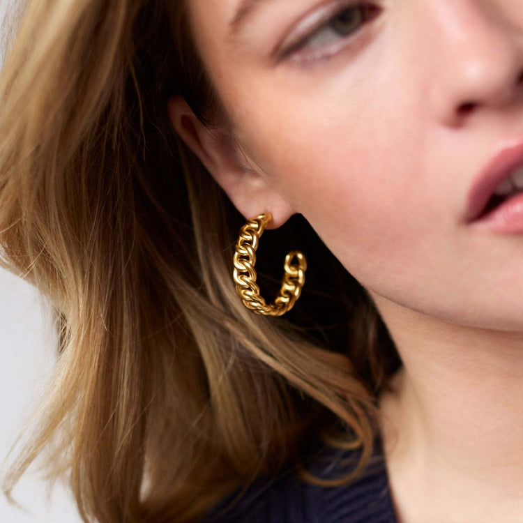 Gold-plated hoop earring with a sleek circular silhouette.
