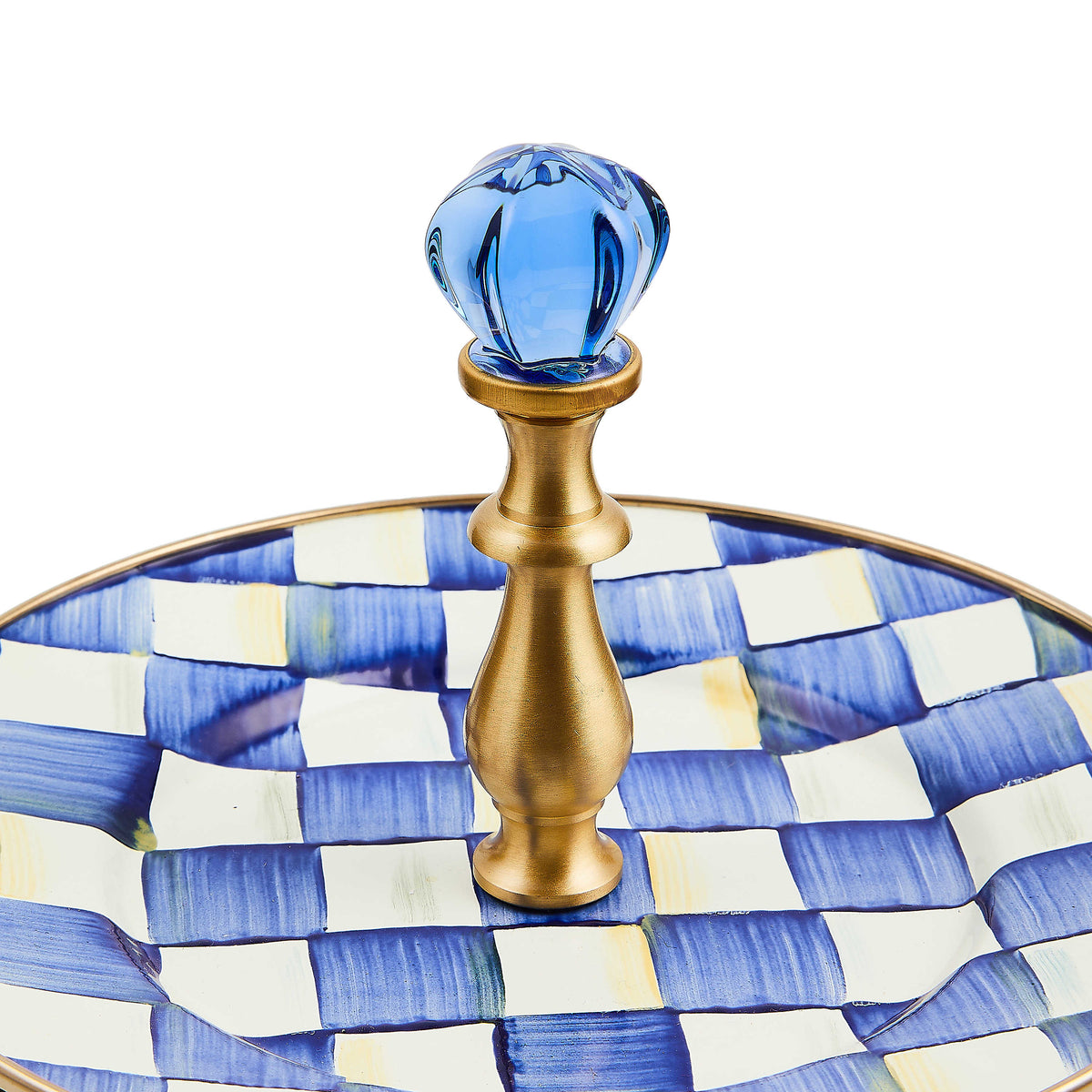 Close-up of the brass handle and blue glass finial on a Royal Check patterned two-tier stand.