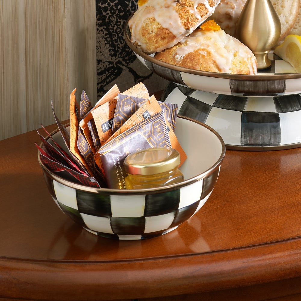 Courtly Check Enamel Everyday Bowl filled with tea packets and a small honey jar on a wooden table.