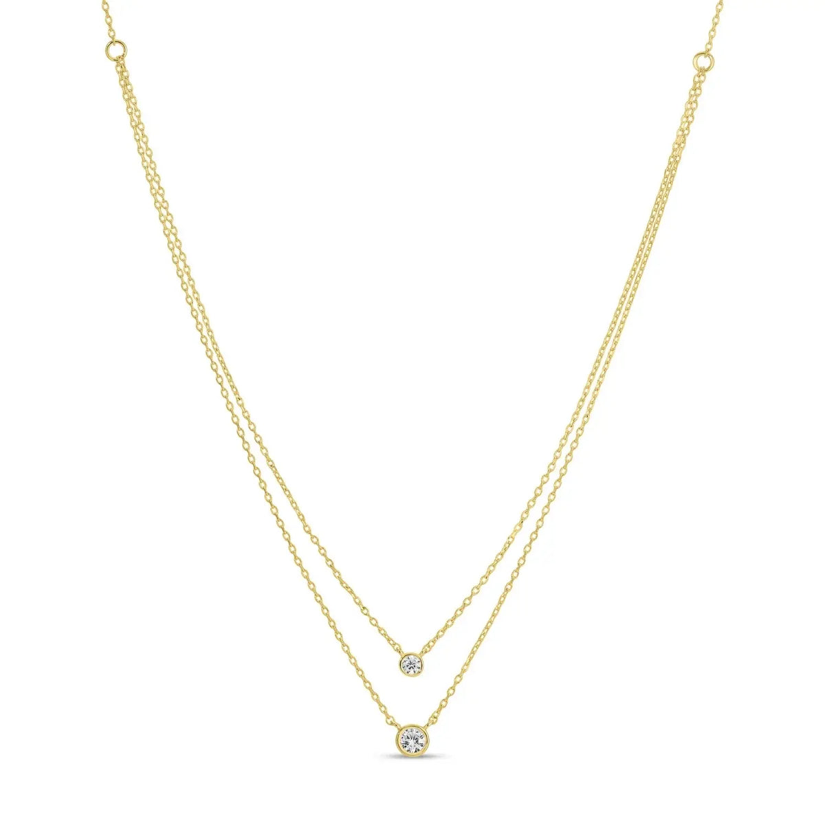 Double layer necklace with two dainty chains featuring cubic zirconia accents in an 18k gold plated brass setting.
