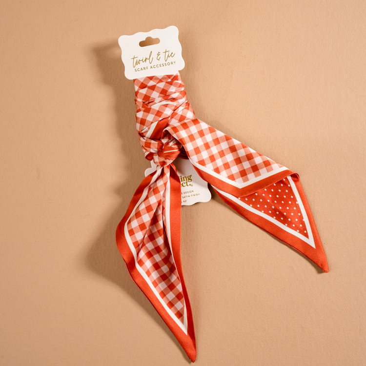 Twirl & Tie Scarf Accessory in red and white gingham and polka dot patterns on a display card.