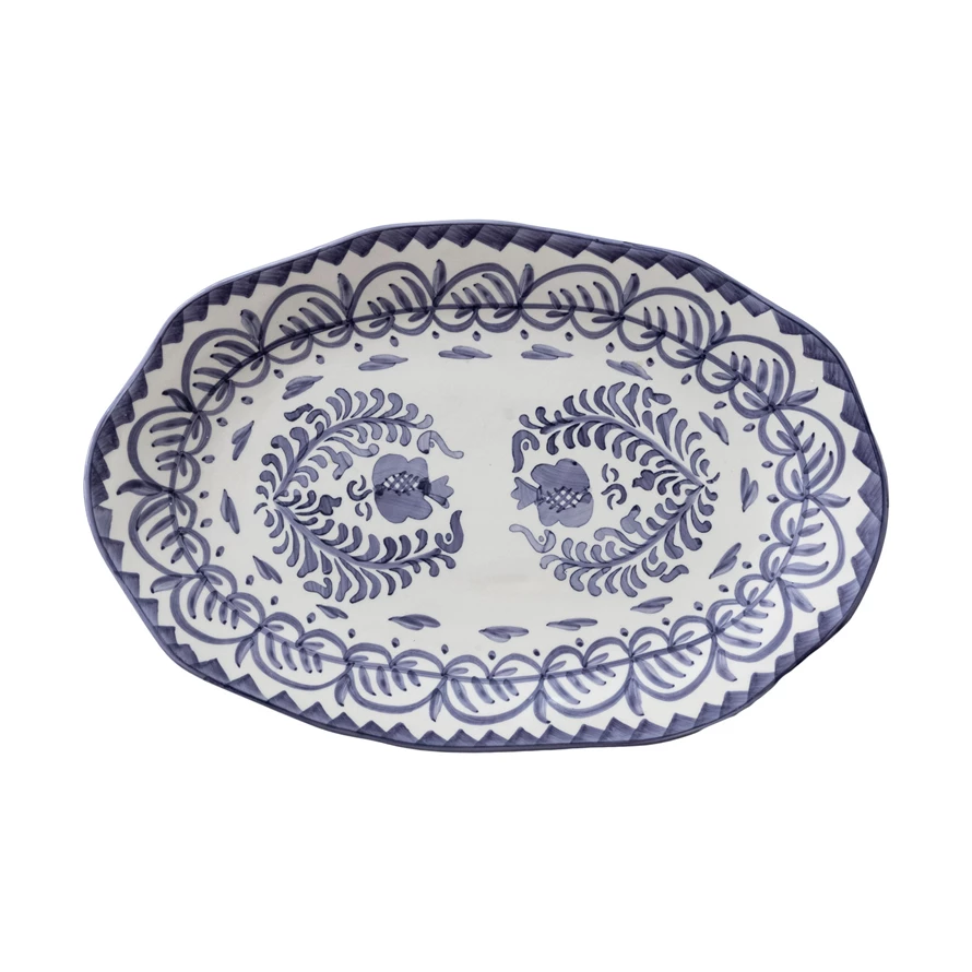Hand-painted blue-and-white stoneware serving platter with organic free-form silhouette and botanical design.