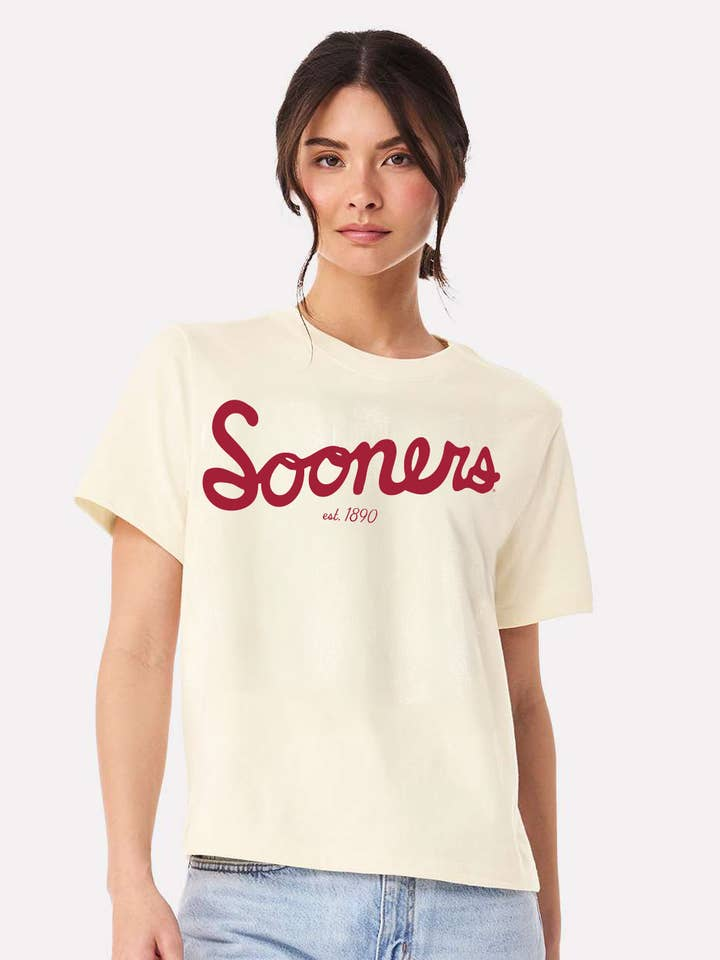 Woman wearing an off-white Emma OU Sooners Bold Script Ellie Heavyweight Tee with crimson lettering.