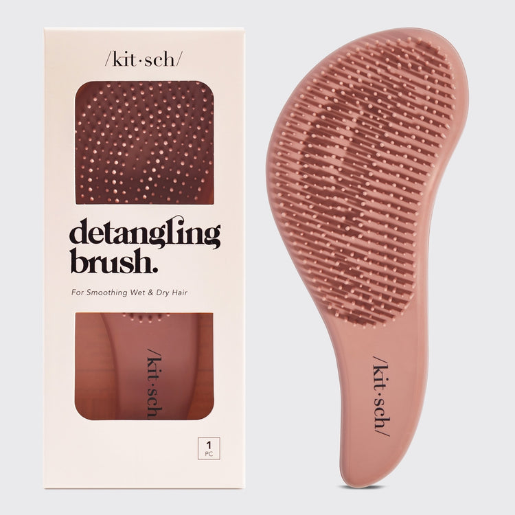 Detangling brush with flexible bristles in sleek black handle designed to smooth tangles and add volume.