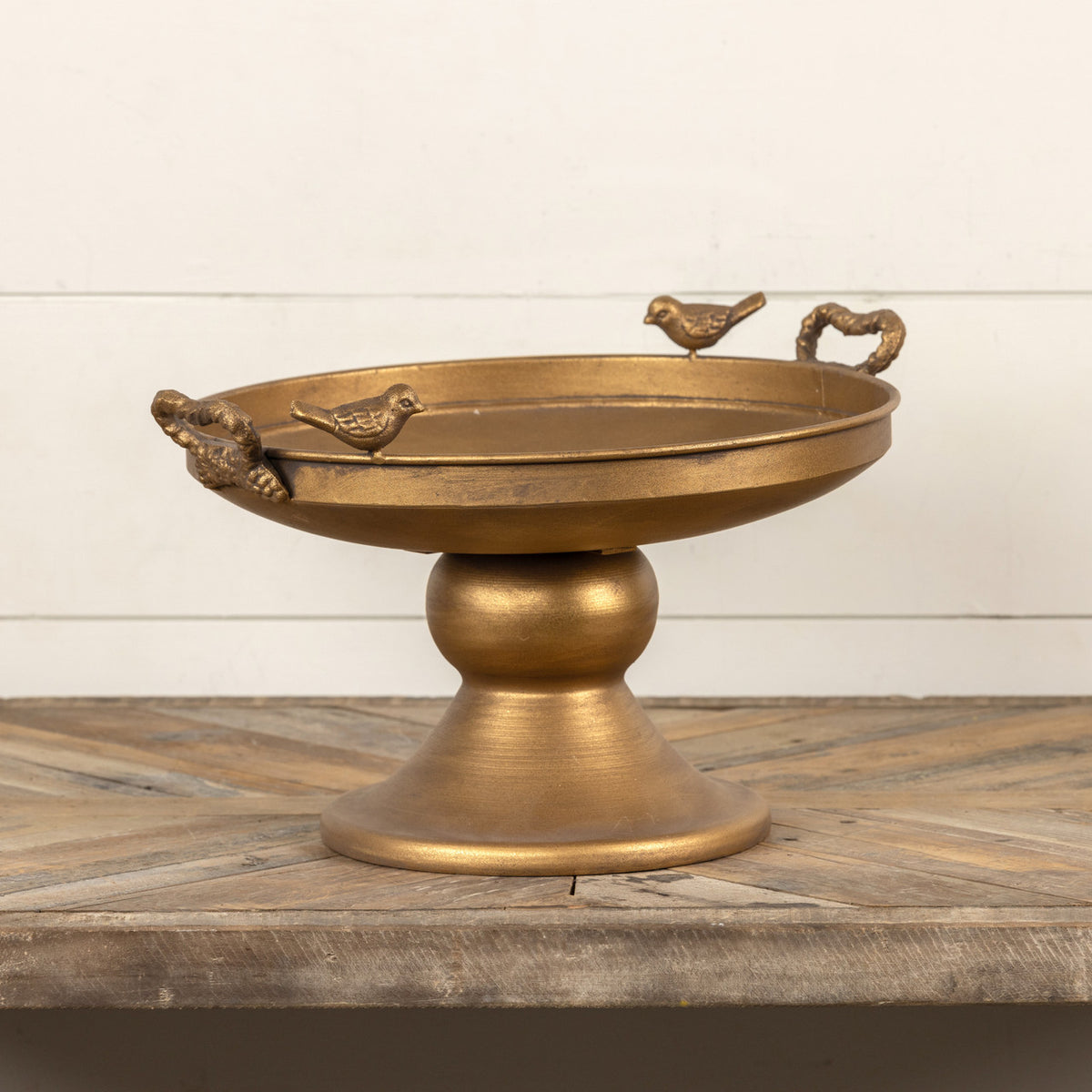 Raised gold metal tray with bird silhouettes on a square surface