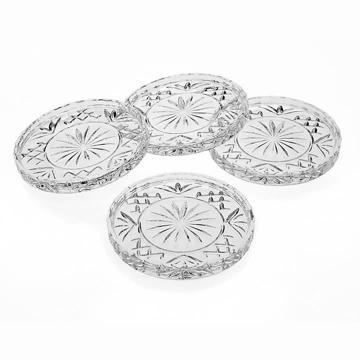 Set of four Dublin crystal coasters with brilliant-cut patterns in clear glass.