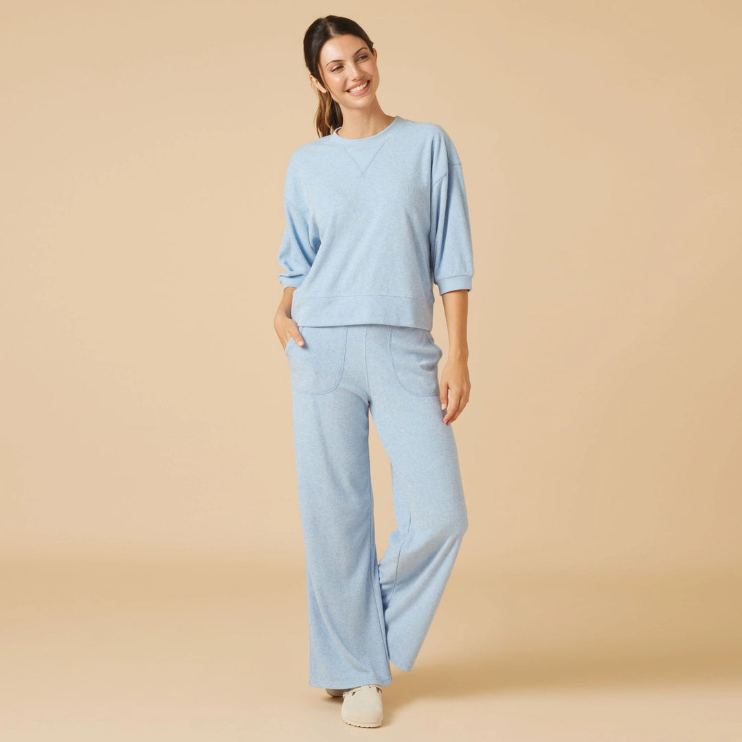 Woman wearing a light blue Daphne Terry cropped sleeve crew neck top and matching wide leg pants.