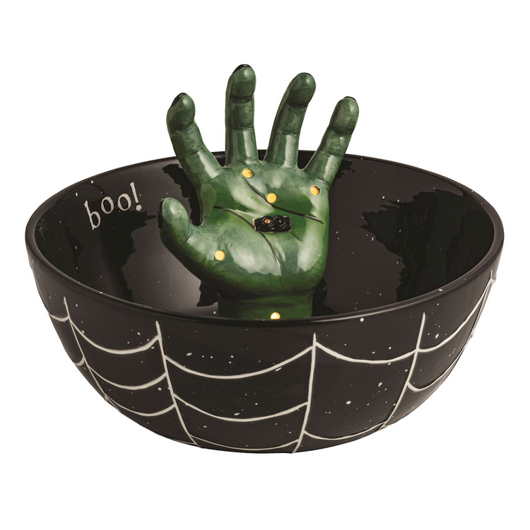 Black ceramic treat bowl with white spiderweb design and a green light-up hand rising from the center
