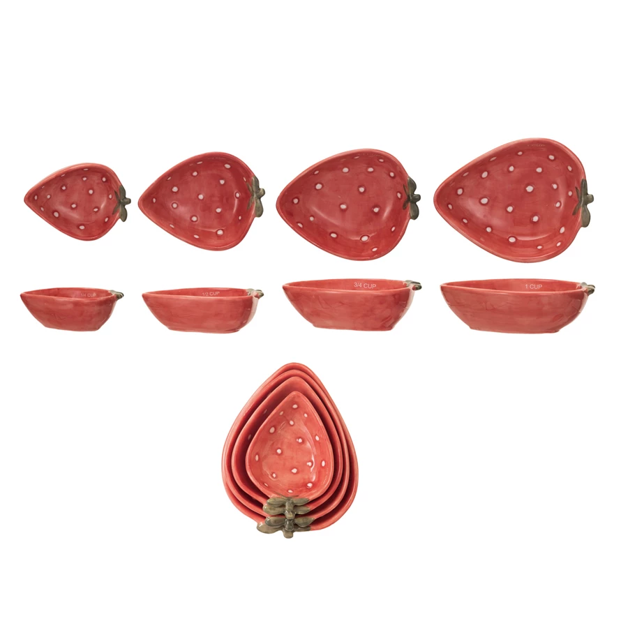 Set of four hand-painted stoneware measuring cups shaped like strawberries in various sizes.