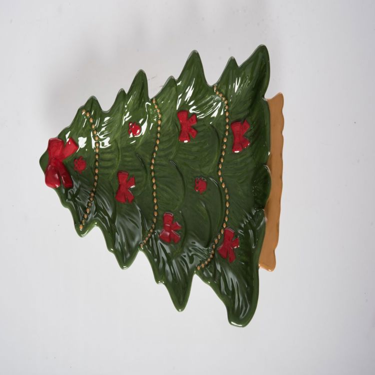 Green ceramic Christmas tree platter with red bows and gold bead garland detail.