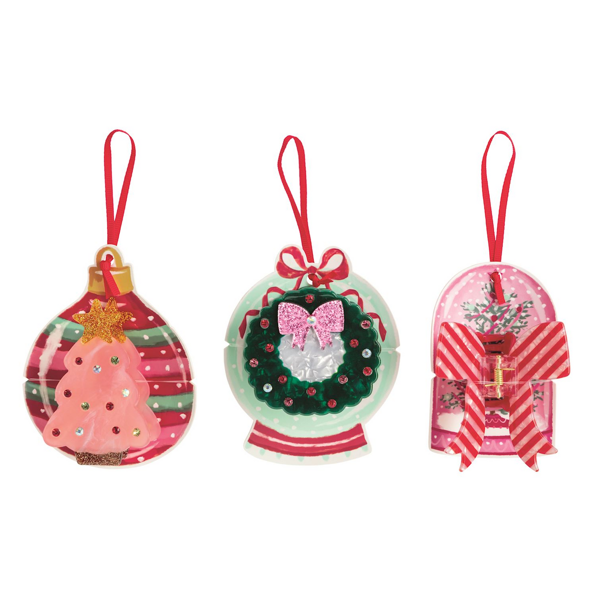 Three holiday-themed claw clips: a pink tree, a green wreath, and a red striped bow.