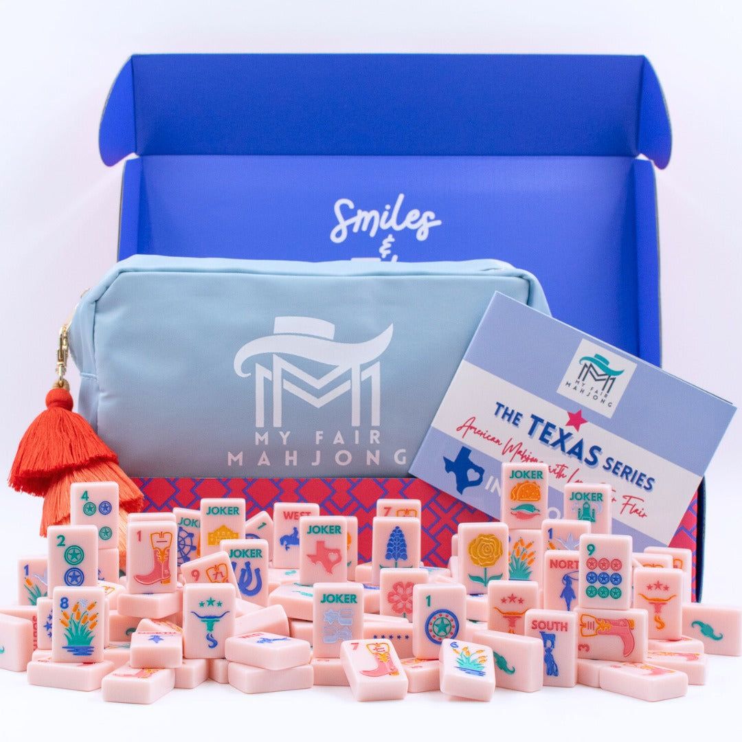 The Texas Series American Mahjong set with pink tiles, blue carrying case, and a blue storage box.