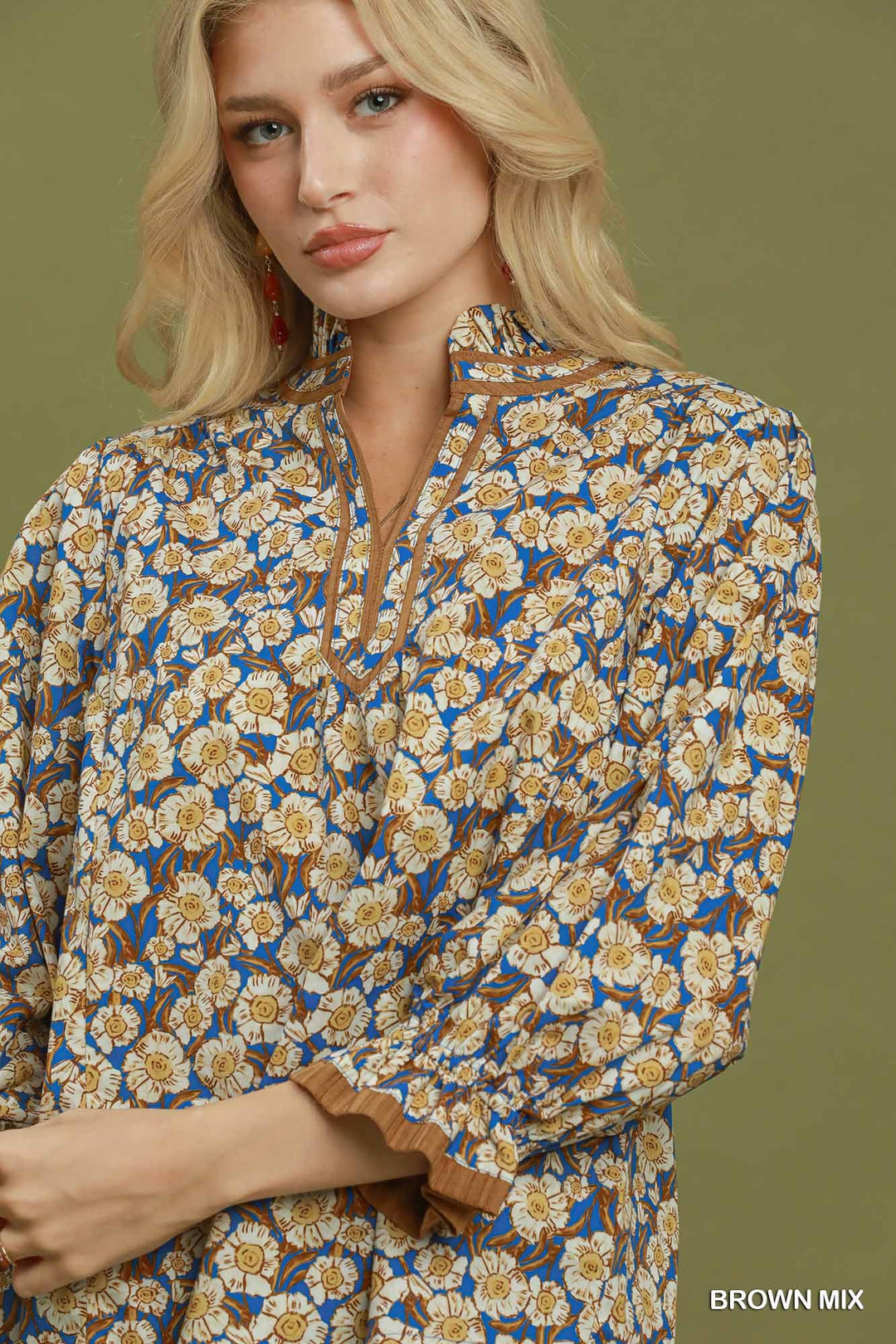 Woman wearing a Kate Mix floral print blouse with a mandarin collar in brown and blue.