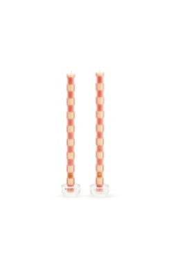 Set of two tall pink and cream checkered dinner candles in clear glass holders.