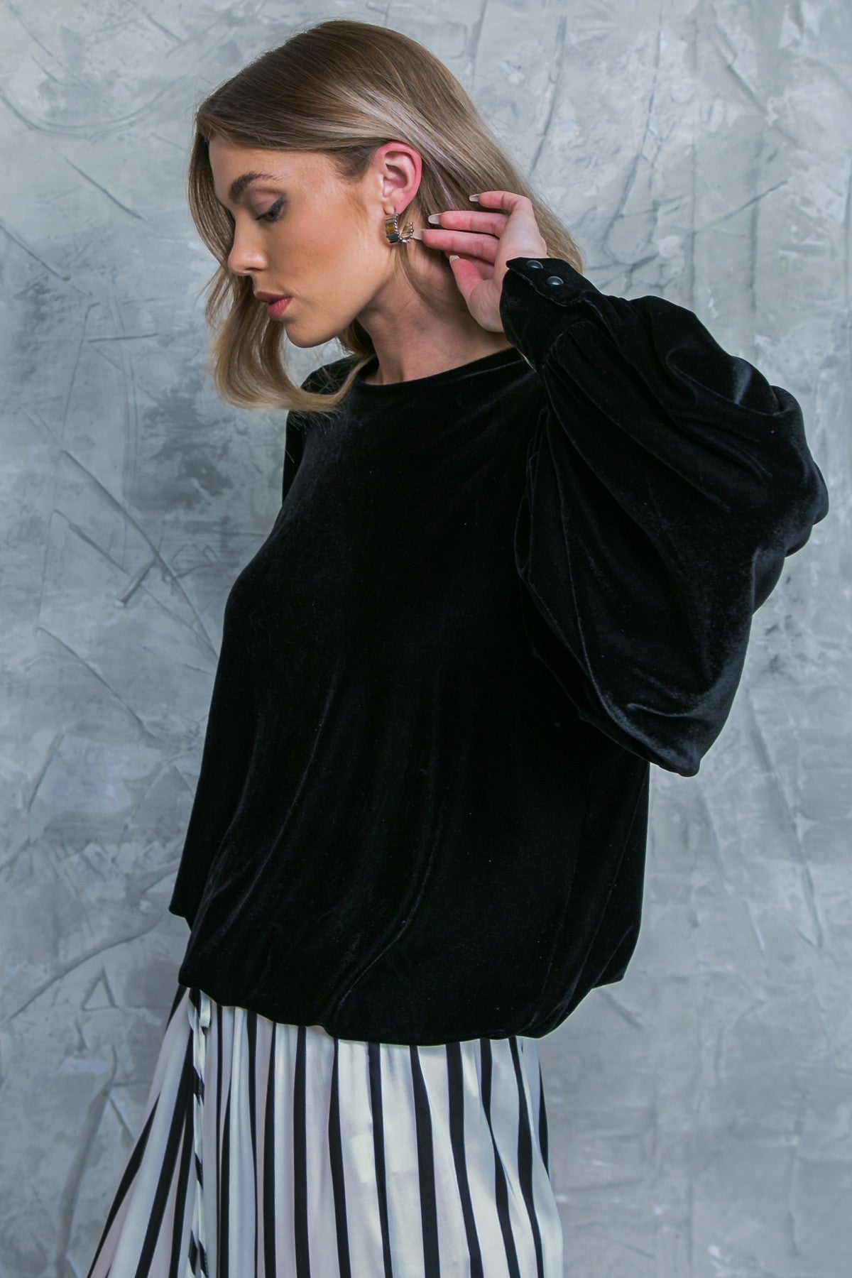 Black velvet Jenny top with voluminous sleeves and a striped skirt.