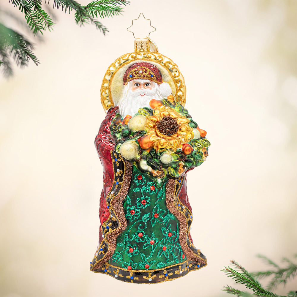 Regal Radiance Santa ornament in green and red robes holding a large sunflower bouquet.