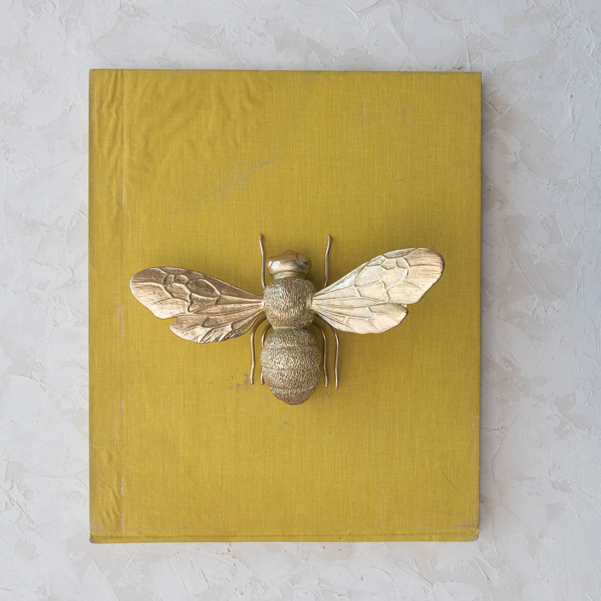 Gold-finish resin bee figurine with pewter accents on a black background.