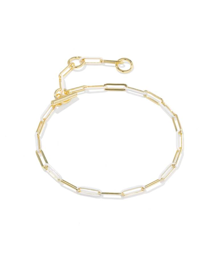 Gold chain bracelet with white enamel links and a toggle closure.