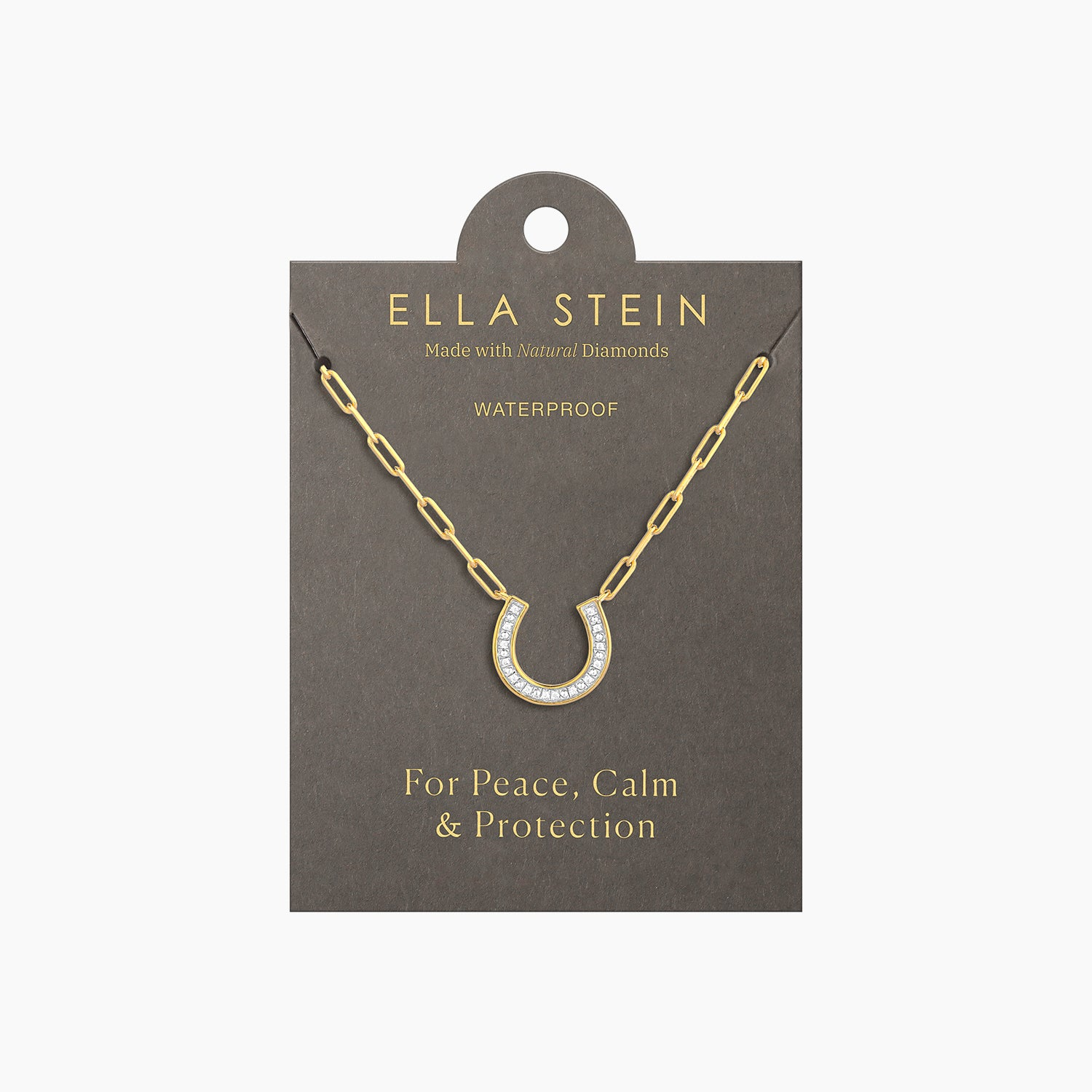Gold horseshoe pendant necklace with diamonds on a paperclip chain, displayed on a grey card.