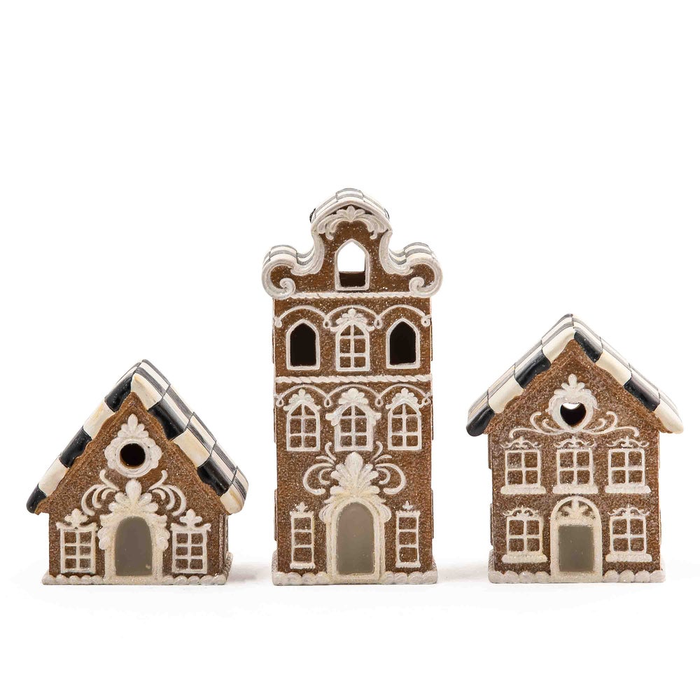 Illuminated gingerbread house made of resin with a festive red roof silhouette.
