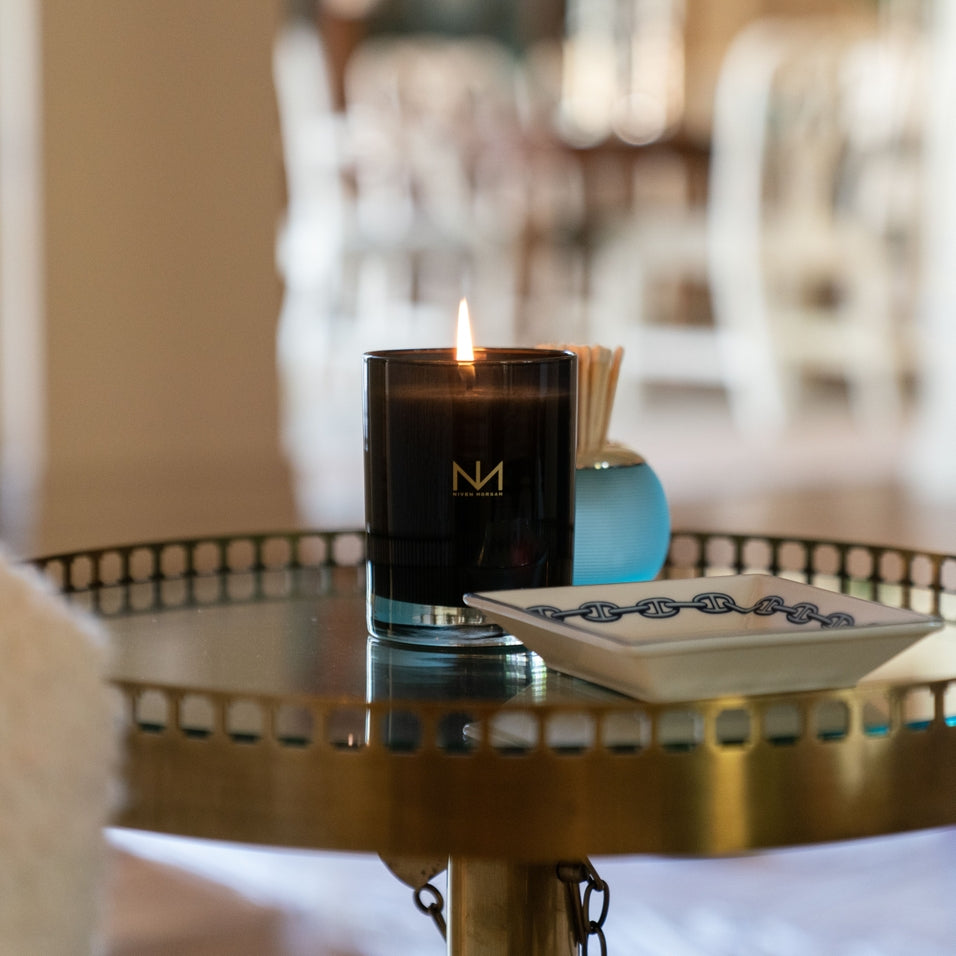 Dark navy glass candle with soy blend wax in a cylindrical container.