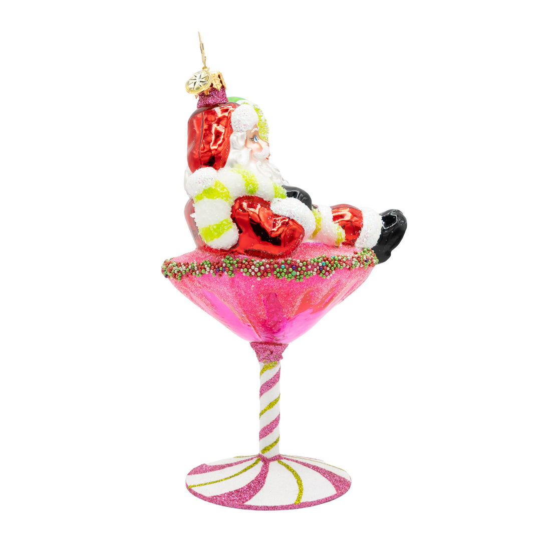 Santa Claus ornament lounging in a pink glittery martini glass with a candy cane stem.