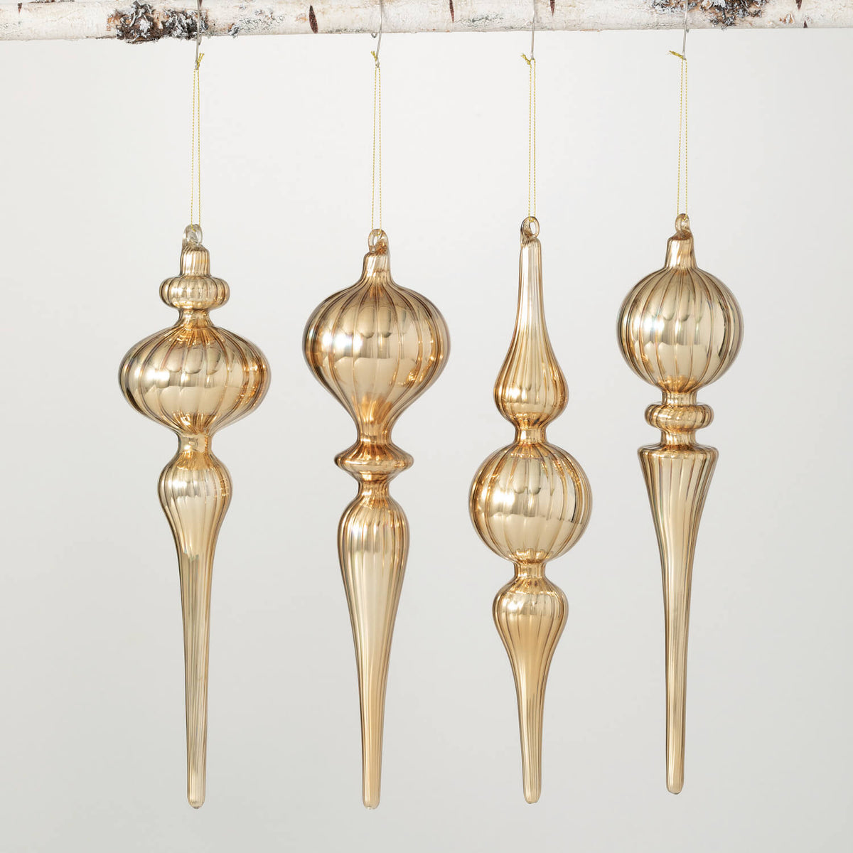 Set of four 12-inch gold glass finial drop ornaments hanging from a branch.