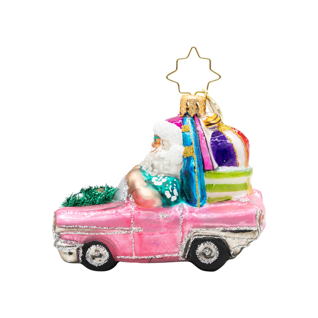 Santa Claus in a pink convertible ornament with a surfboard and beach gear.