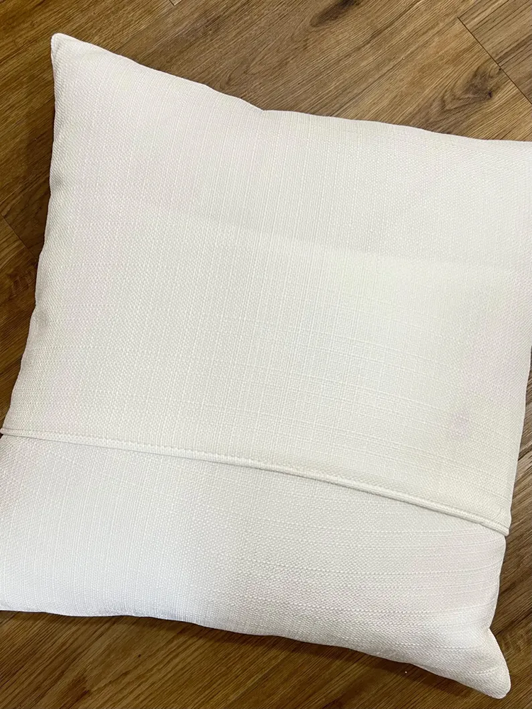 Handmade USA pillow with a classic square silhouette in neutral tones.