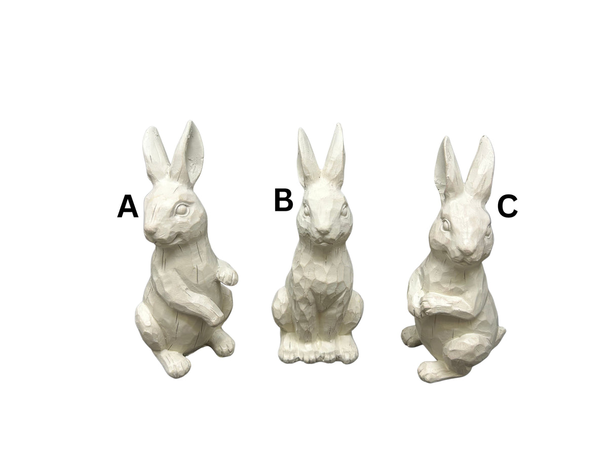 Three small white resin standing rabbit figurines in different poses with carved wood textures.