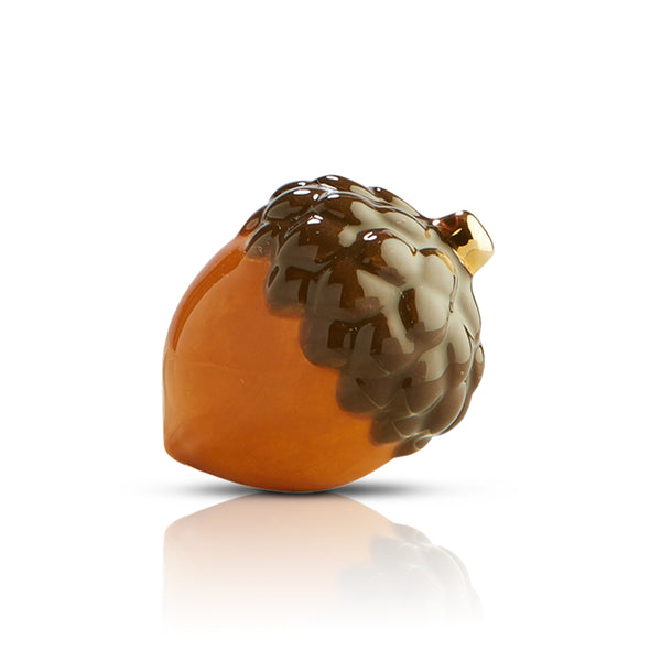 Glossy ceramic acorn figurine with a dark brown textured cap and smooth amber-colored base.