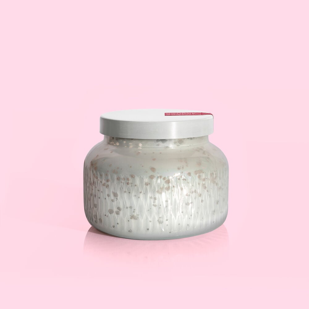 Mercury Holiday Signature jar candle in a clear glass vessel with an amber-colored wax and white wick.