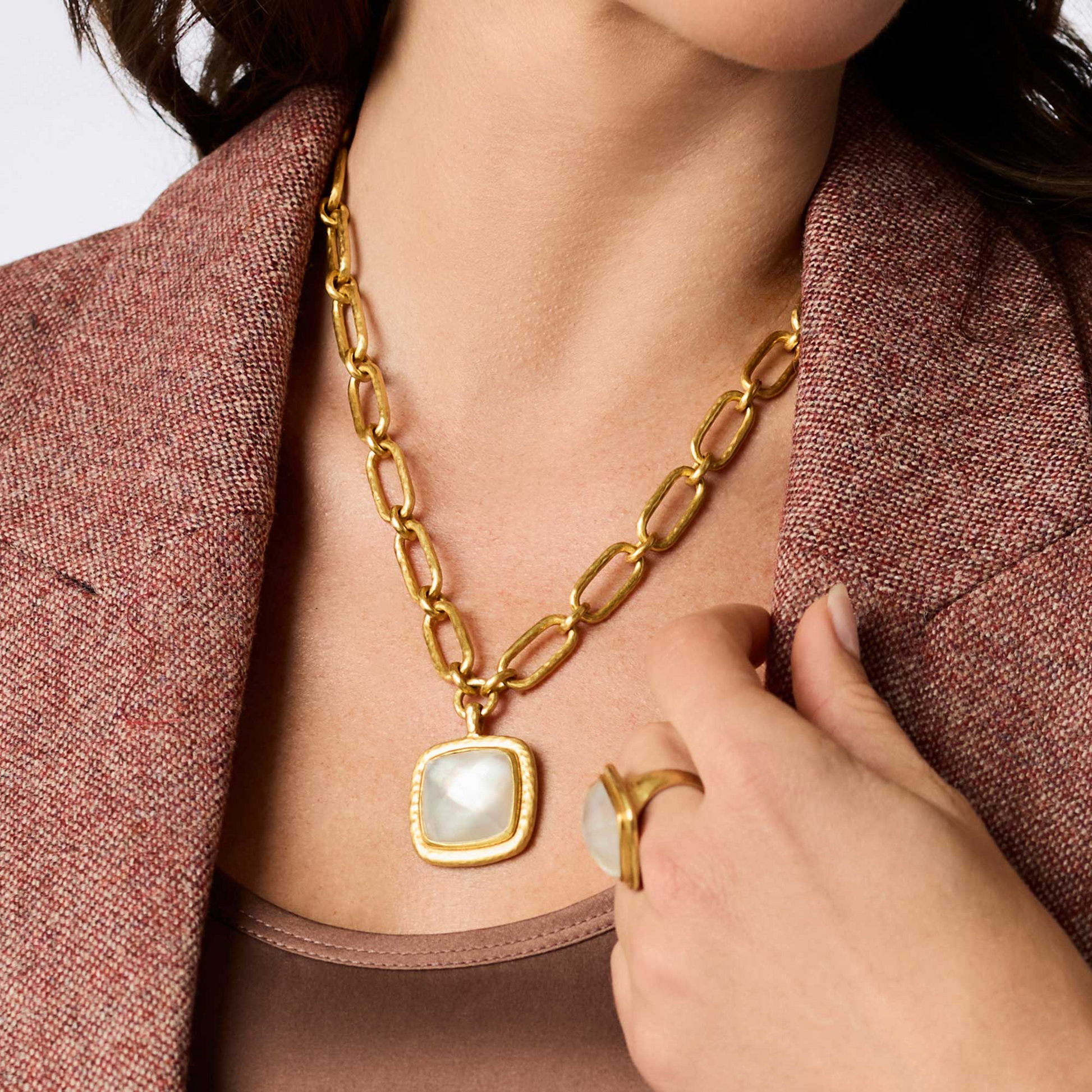 Woman wearing the Sahara Statement Necklace, a 24K gold plate chain with a square glass pendant.