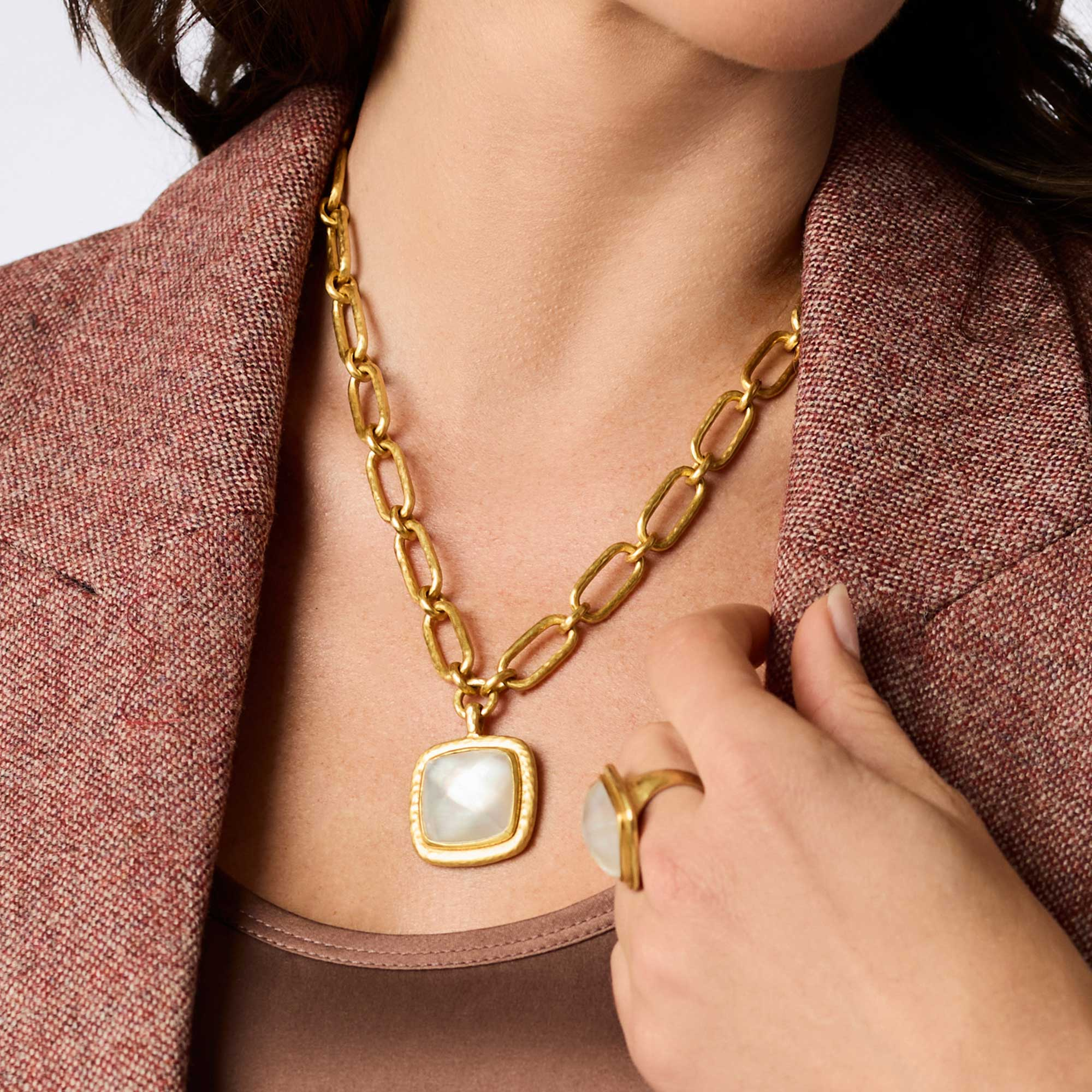 Woman wearing the Sahara Statement Necklace, a 24K gold plate chain with a square glass pendant.