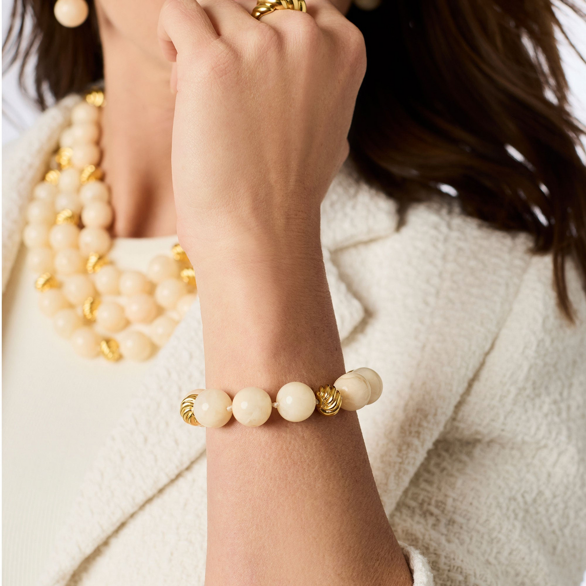 Model wearing the Ravello Bracelet featuring large cream resin beads and 24K gold-plated accents.